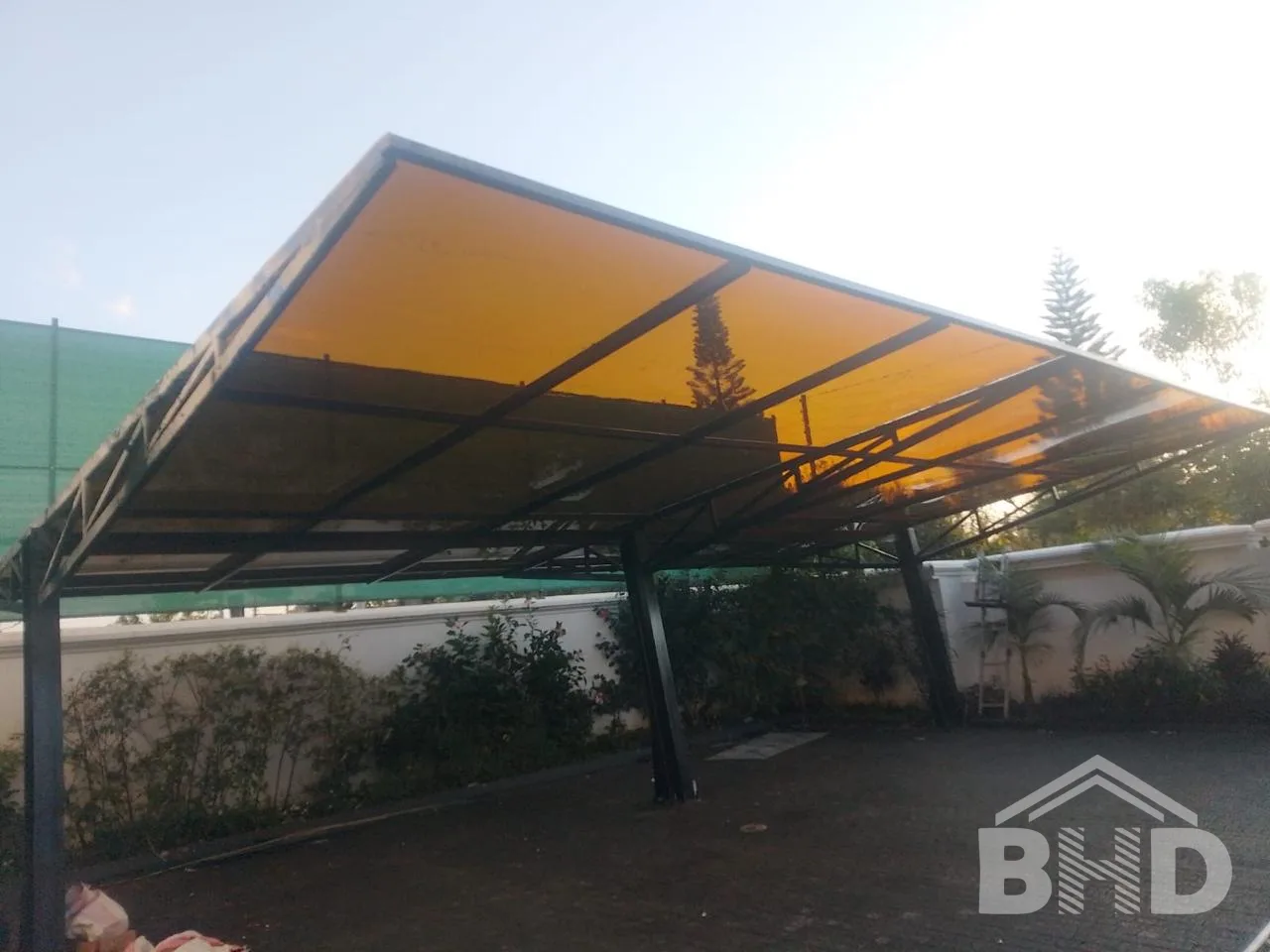 Bronze-tinted solid polycarbonate carport roof on a steel frame at a Nairobi property, supplied by BHD Kenya